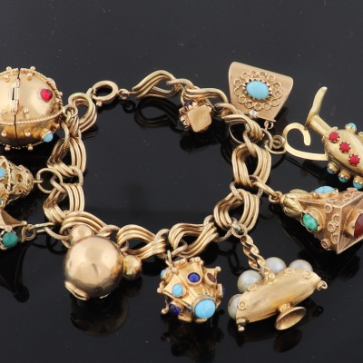 Italiaanse 18 krt gouden armband met gedraaide schakels en voorzien van 11 bedels, w.o. bezet met turkoois en lapis lazuli